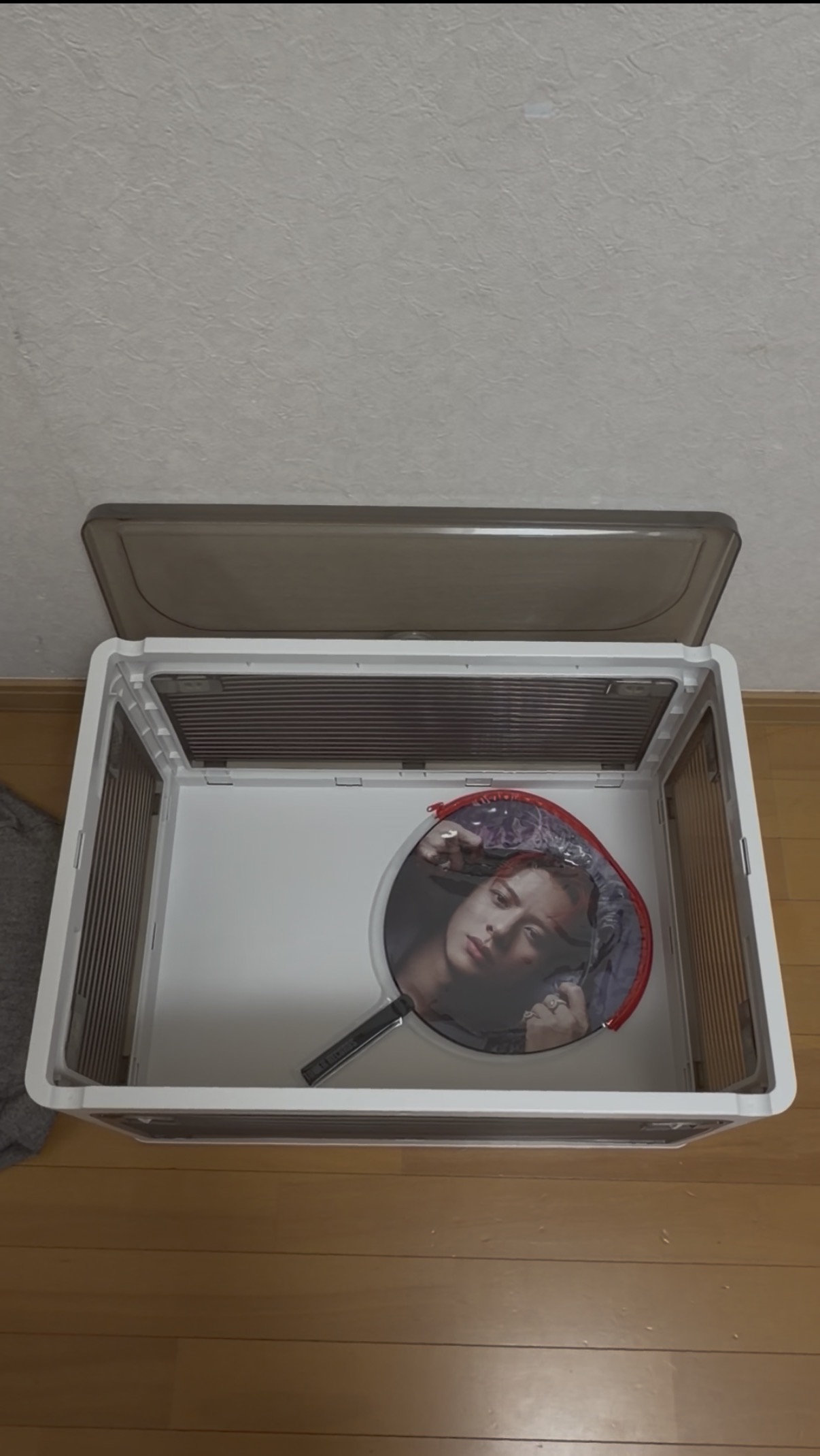 くうが収納ボックスにカバー付きのうちわを入れている様子